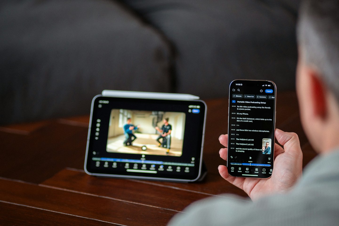 Person reviews video transcript on tablet and phone.